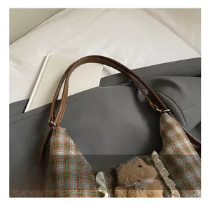 Detail of plaid tote with white ruffled edges and a cute brown plush bear charm