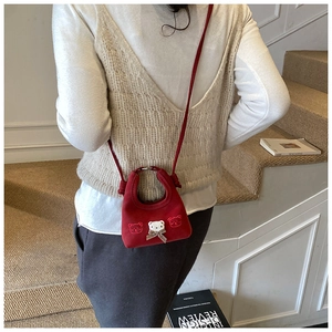 Toddler girl wearing a mini red crossbody bag with cute bear patches and a gold bow