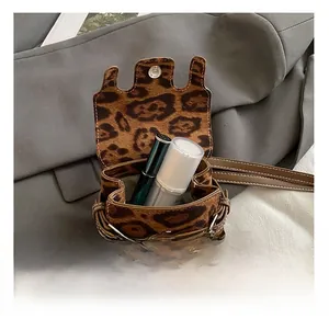 Detail showing internal capacity of leopard print mini bag with metal snap closure