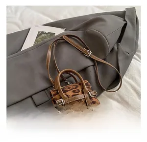 Detail of leopard print mini bag showing faux hair texture and brown leather handle
