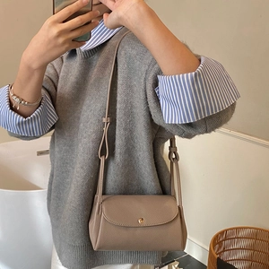 Brown lychee leather crossbody bag with golden metal buckle and minimalist shoulder strap
