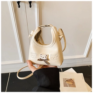 Detailed view of cream beige mini bag with plush 3D bear and plaid bow decoration