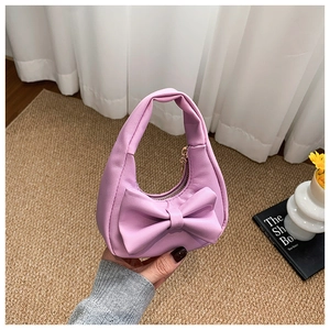 Close-up of a mini purple girls handbag with a large bow and gold zipper detail