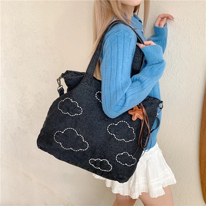 Deep blue denim tote bag with white cloud embroidery and a leather star charm