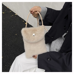 Detail der flauschigen beigen Handytasche mit Silberschnalle und Lederriemen