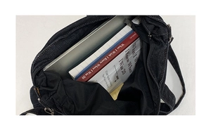 Vista interna della borsa in denim capiente con laptop e libri inclusi