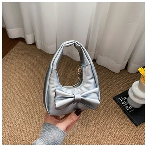 Detailed view of silver metallic mini handbag with bow and textured PU leather finish