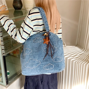Chic light blue denim tote bag with white cloud embroidery and star charm on shoulder