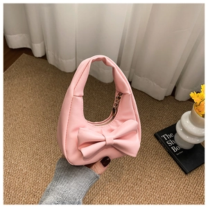 Close-up of pink bow handbag with premium synthetic leather texture and gold zipper