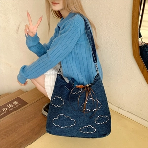 Large blue denim tote bag with white cloud quilting and brown tassel drawstring detail