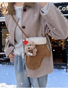 Detailed view of plush Christmas stocking crossbody bag with a cute teddy bear charm