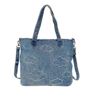 Blue washed denim tote bag with white cloud embroidery and adjustable shoulder strap