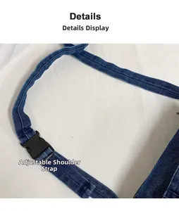 Détail de la bandoulière réglable noire et boucle en plastique sur sac en jean bleu marine