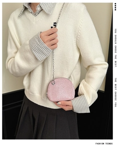 Pink sequin shell-shaped mini bag with silver chain strap shown on a model
