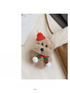 Détail d'un porte-clés ours en peluche avec bonnet de Noël et écharpe sur un sac