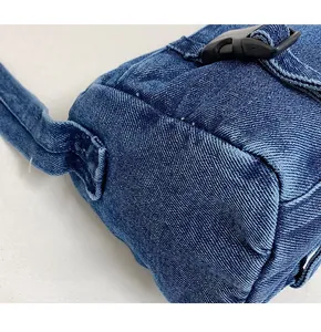 Vue détaillée de la structure latérale et de la boucle du sac bandoulière en jean