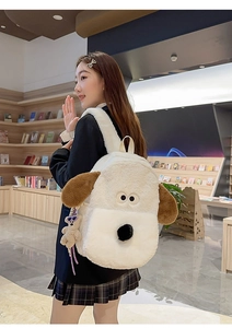 Detail of cute plush cartoon dog backpack with soft texture and hanging bear charm