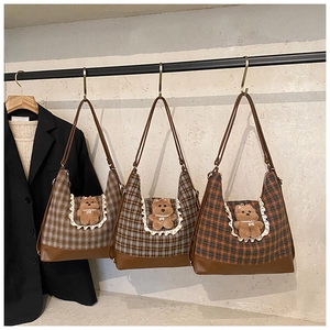 Three plaid shoulder bags featuring plush bear charms and lace details in various colors