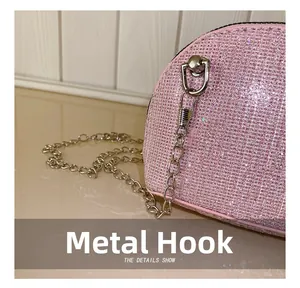 Detailed close-up of the silver metal hook and pink sequin surface of the shell bag
