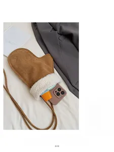 Vue intérieure d'un sac bandoulière en forme de moufle contenant un smartphone et soin