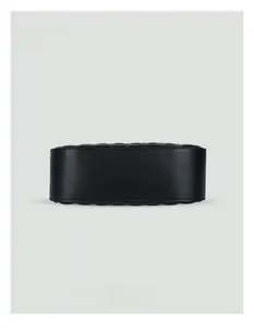 Detail view of the oval-shaped base with fine leather texture on a black quilted hobo bag