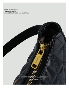 Close-up of black quilted leather with gold-tone LANBAI zipper on a stylish hobo bag