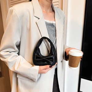 Mini black leather handbag for girls featuring a large bow and elegant handle
