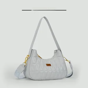 Macro detail of triangle quilted fabric and gold hardware on grey shoulder bag