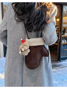 Close-up of glove-shaped crossbody bag with white faux fur trim and cute bear charm