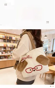 Close-up of cream canvas tote bag with 3D cartoon dog embroidery and wide khaki strap