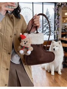 Detail of plush Christmas stocking bag with cute teddy bear charm and soft white fur trim