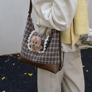 Kids plaid crossbody bag with plush bear charm and ruffled lace trim in autumn setting