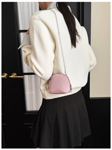 Girl's pink macaron sequin shell bag with silver chain strap shown in a real-life outfit