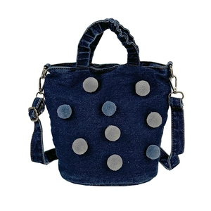 Deep blue denim bucket bag with plush polka dots and adjustable shoulder strap