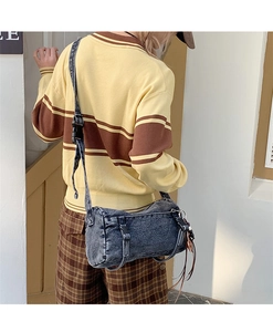 Détail du sac bandoulière cylindrique en denim délavé gris foncé avec boucle et lanière