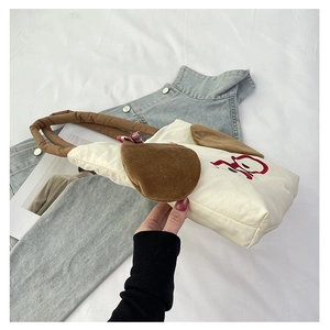Close-up of off-white canvas bag featuring cute cartoon dog ears and brown padded handles