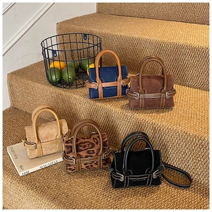 Micro bags in suede, denim, and leopard print finishes displayed on warm stairs