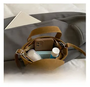 Vista superior de un bolso cuadrado marrón que muestra el interior y la cremallera