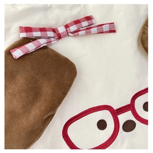 Close-up of cute cartoon embroidery on a soft brown velvet kids crossbody bag