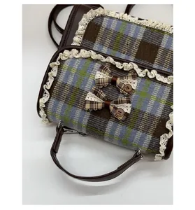 Detail of plaid kids backpack with lace trim, check bows, and brown leather strap