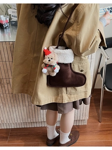 Detail of plush Christmas boot bag with cute bear charm and soft faux shearling trim