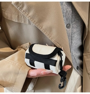 Detailaufnahme einer stilvollen Mini-Schlüsseltasche mit Karabinerhaken am Model
