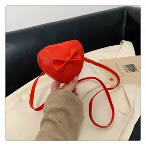 Detailed view of heart-shaped crossbody bag for girls with leather bow and zipper