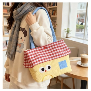 Detail of creative house-shaped canvas shoulder bag with cartoon face and red checkered roof