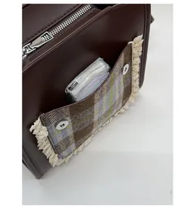 Detail of plaid pocket on kids bag with beige lace trim and silver magnetic buckle