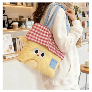 Detail of cute yellow cartoon canvas tote bag with red checkered lid and blue handle
