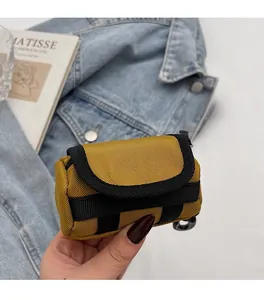 Nahaufnahme der gelben Mini-Tasche aus strukturiertem Nylon mit schwarzem D-Ring-Haken