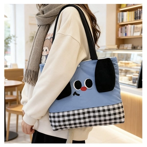 Detail of blue canvas kids tote bag featuring a cute cartoon dog and checkered pattern