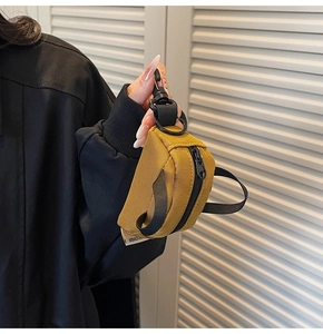 Detail of yellow nylon mini coin purse with plastic swivel hook held by a model