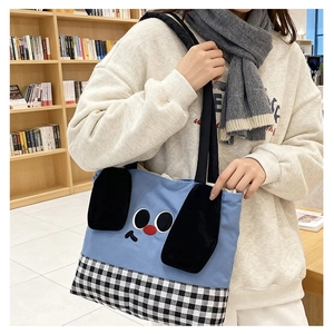 Detail of blue canvas kids tote bag with cute dog face and black and white plaid bottom